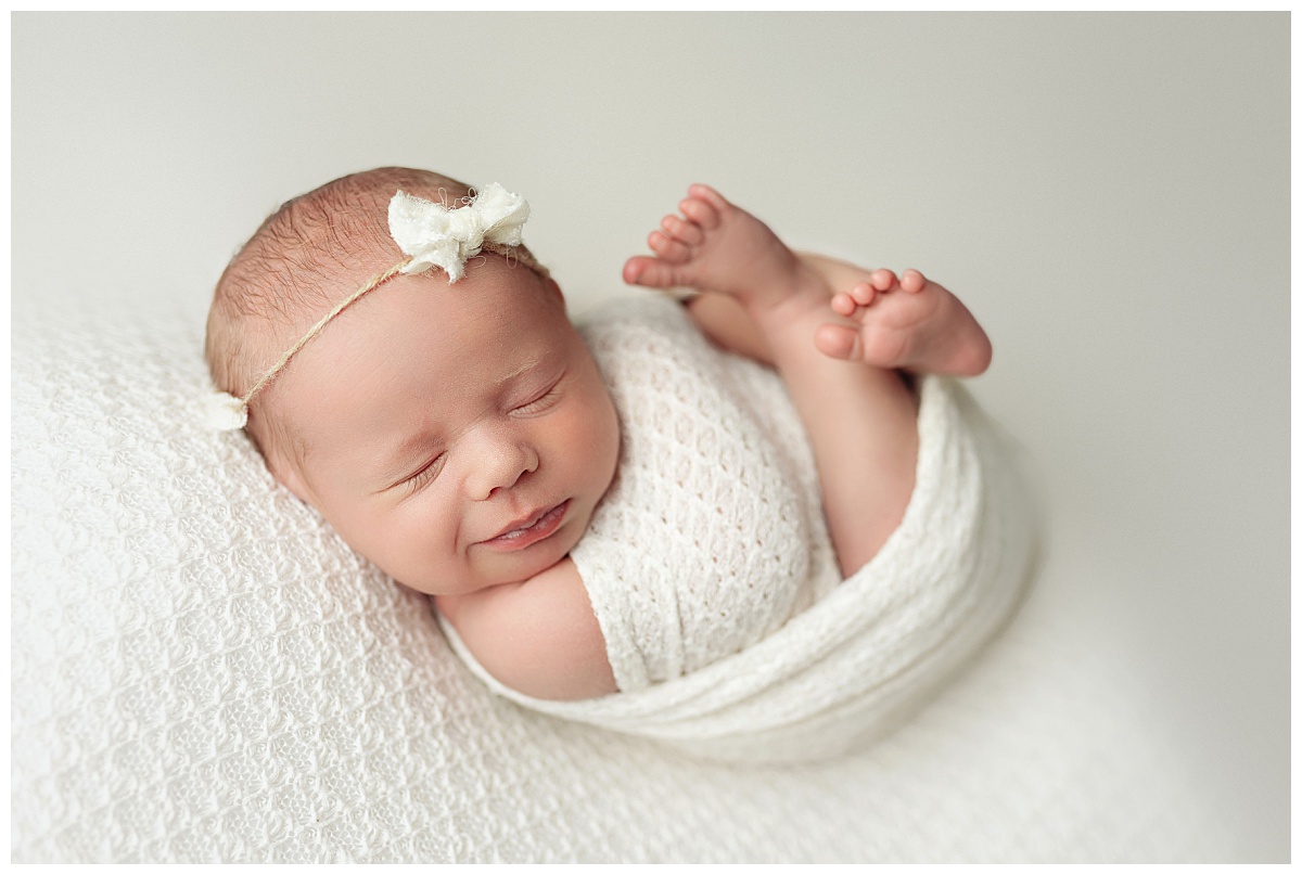 baby smiles during delicate newborn session