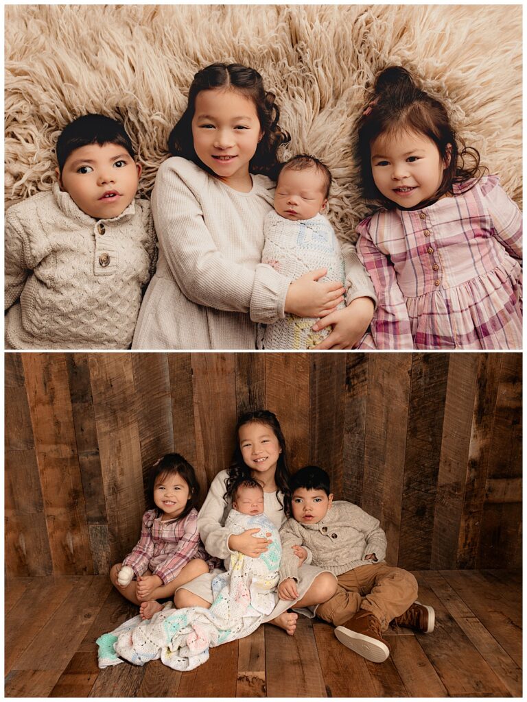 siblings lay holding new baby during family newborn studio session