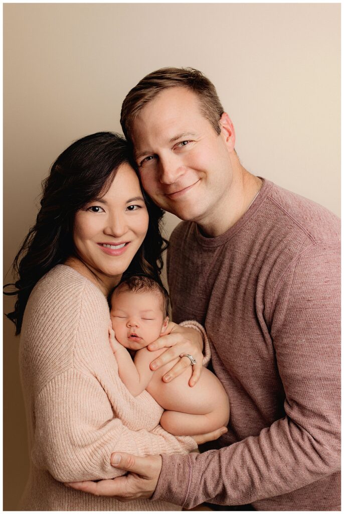 parents hold new baby by Amy Yang Photography