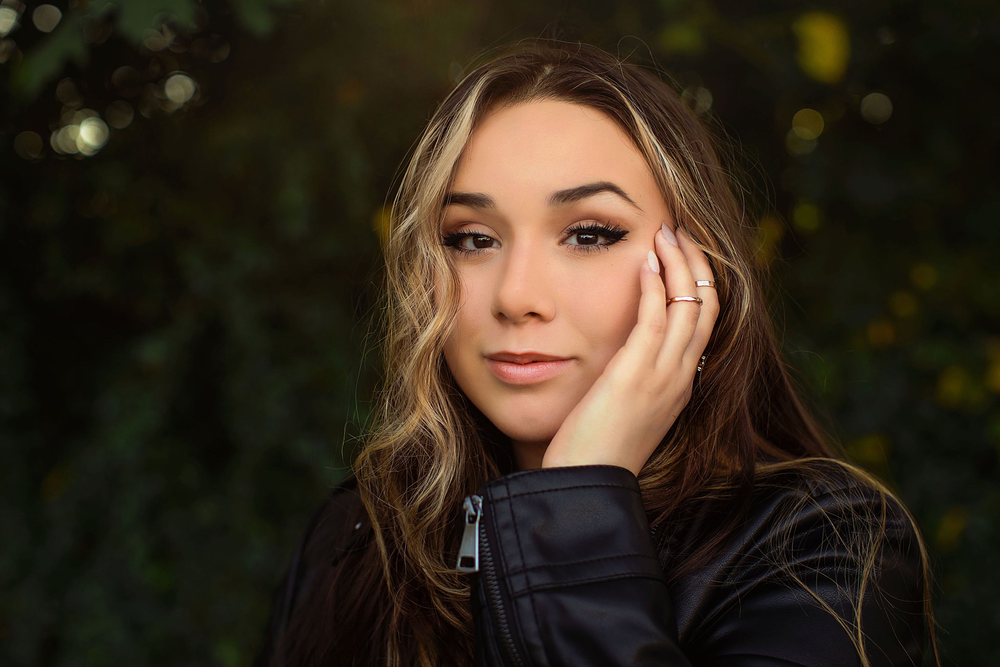 girl places hand next to face during senior portraits