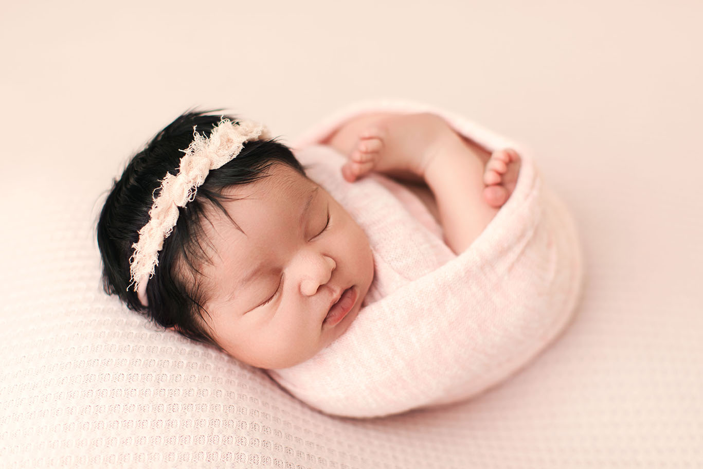 newborn baby girl on pink blanket