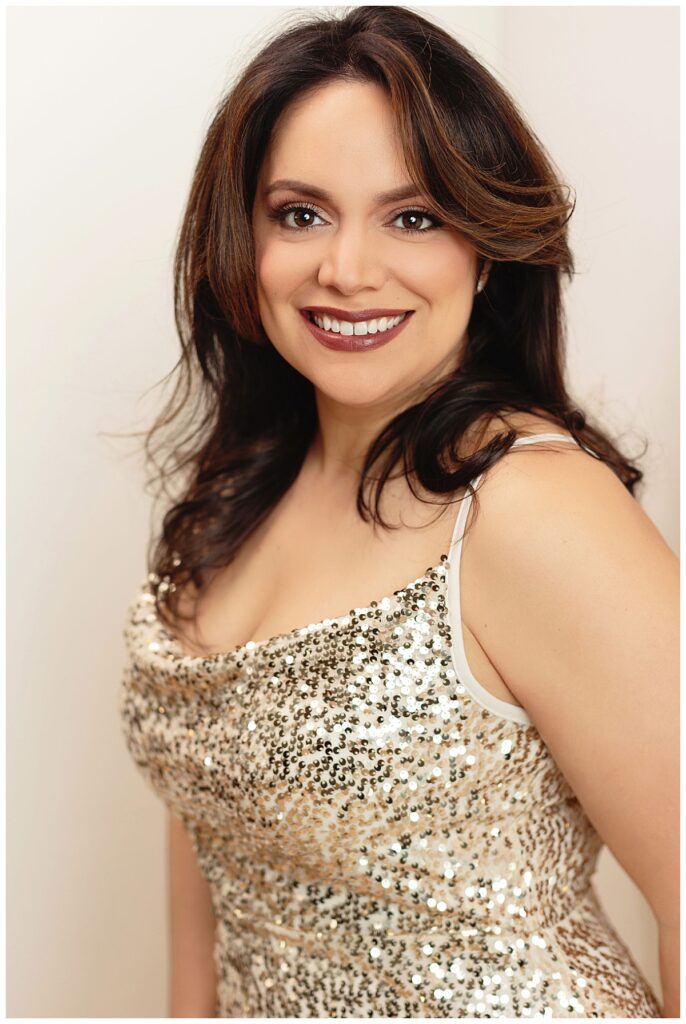 woman smiles in gold sequined dress during women's portrait session 