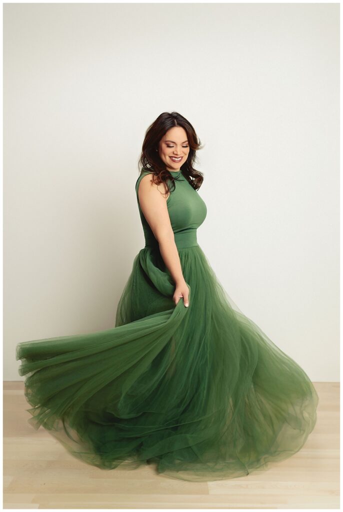 woman twirls in a flowy green dress by Amy Yang Photography