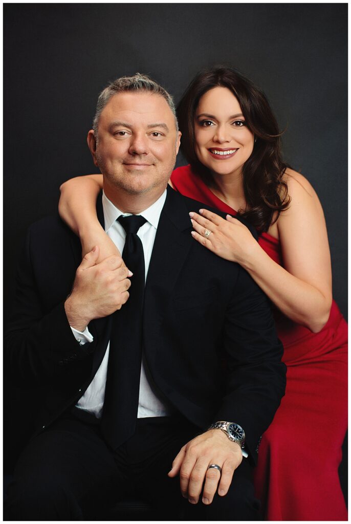 couple smiles as they hold hands during women's portrait session