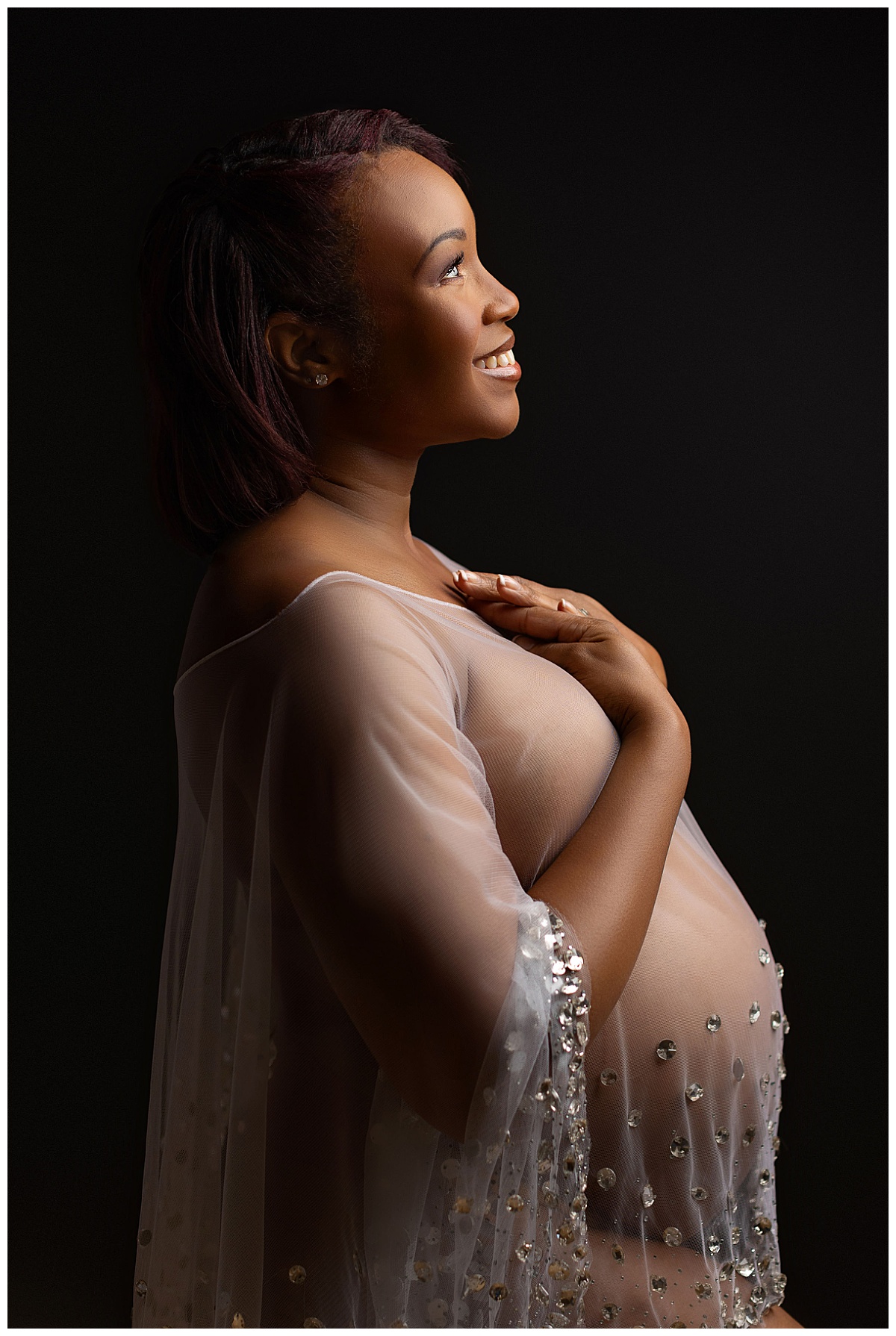 mother holds hands to heart as she smiles during legacy maternity session
