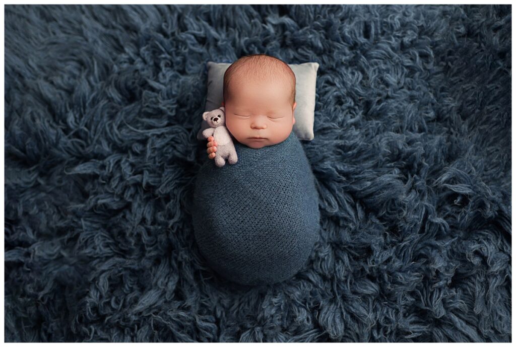 little one's tiny fingers hold small teddy by Amy Yang Photography