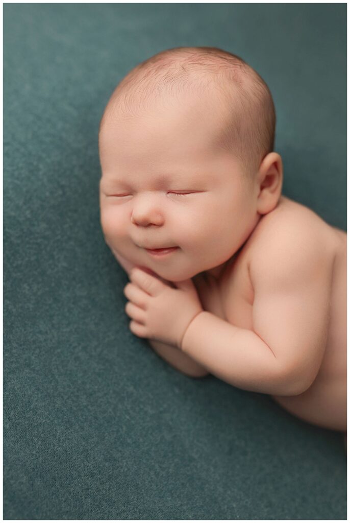 infant rests head on hands by Charlottesville newborn photographer