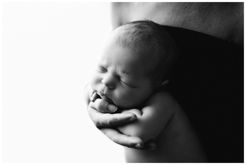 infant rests head on mom's hand by Charlottesville newborn photographer