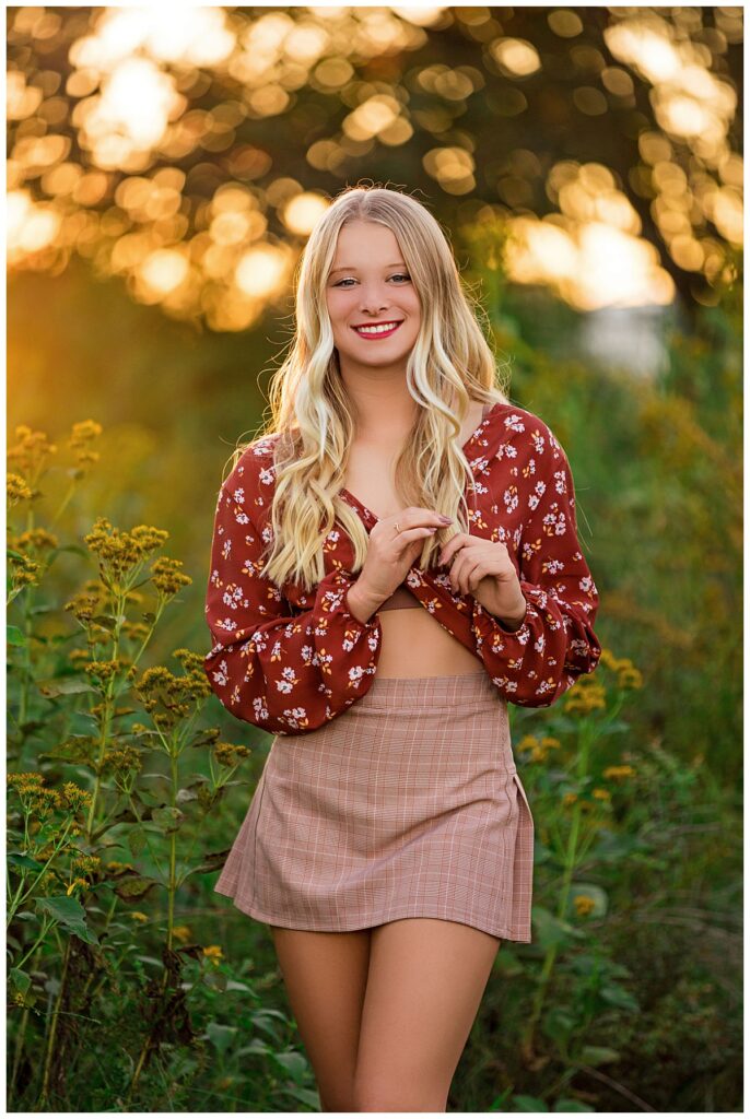 blonde plays with hair with golden light behind her by Amy Yang Photography