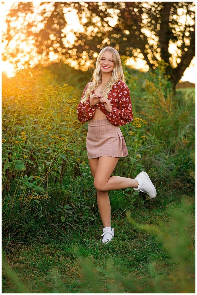 girl plays with hair and kicks up foot during senior session