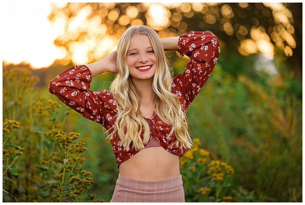 high school student smiles with hands behind her head by Charlottesville luxury photographer